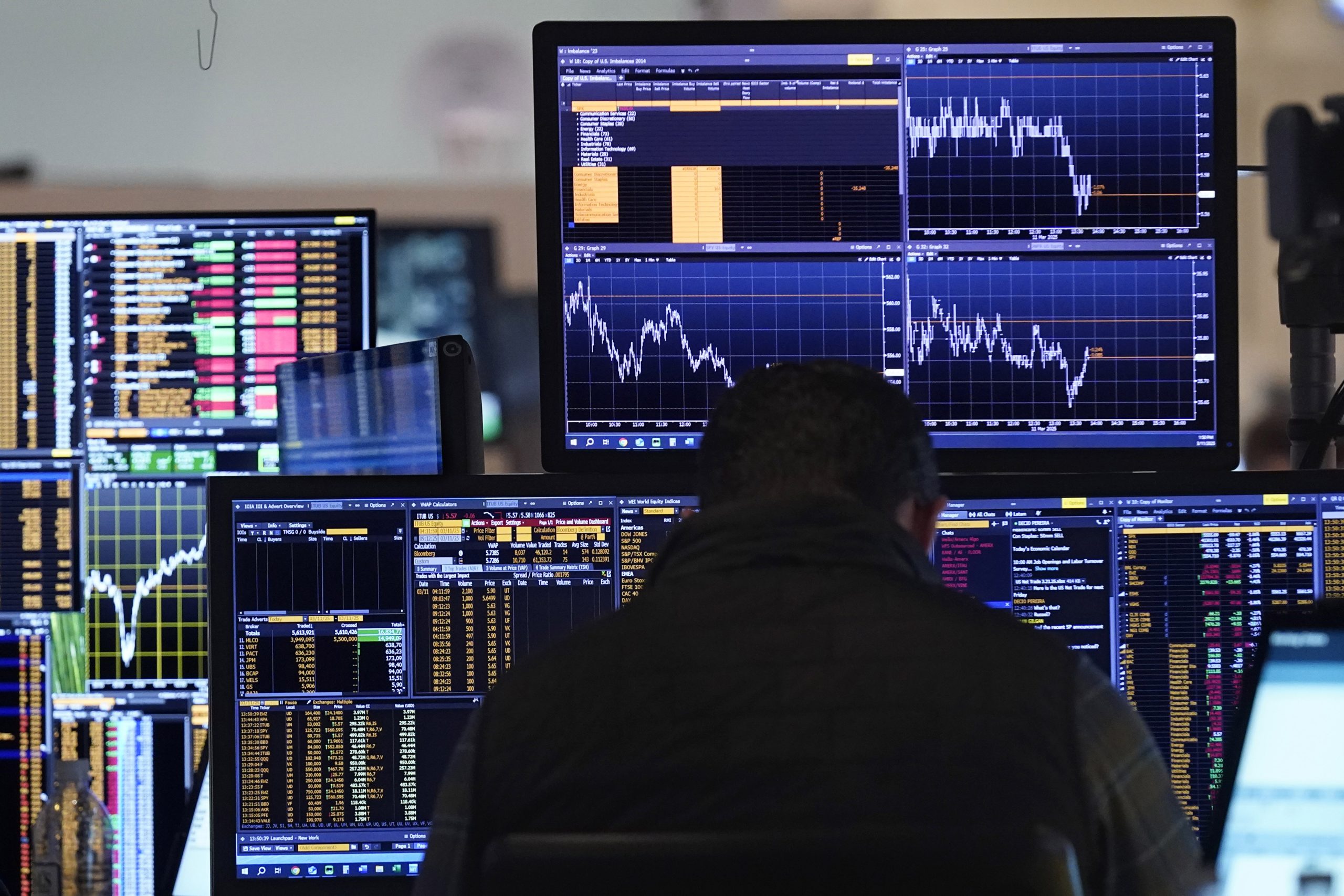 A trader works on the floor of the New York...